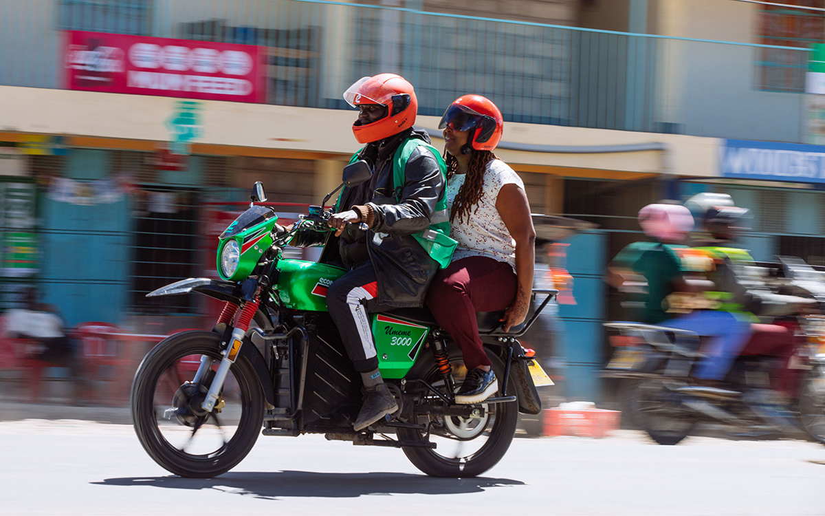 Male driver lifts a female customer on the back of his e-bike